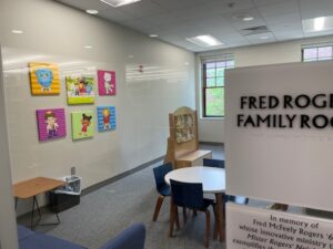 View through door into family room with coloured artwork and toys