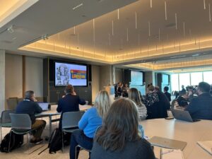 Conference attendees in a classroom look at a presentation