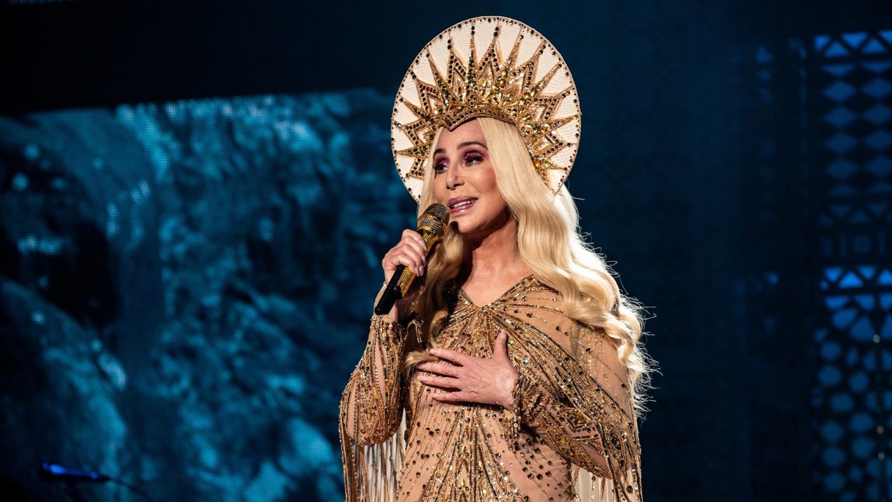 Cher wearing a halo and standing like a religious icon