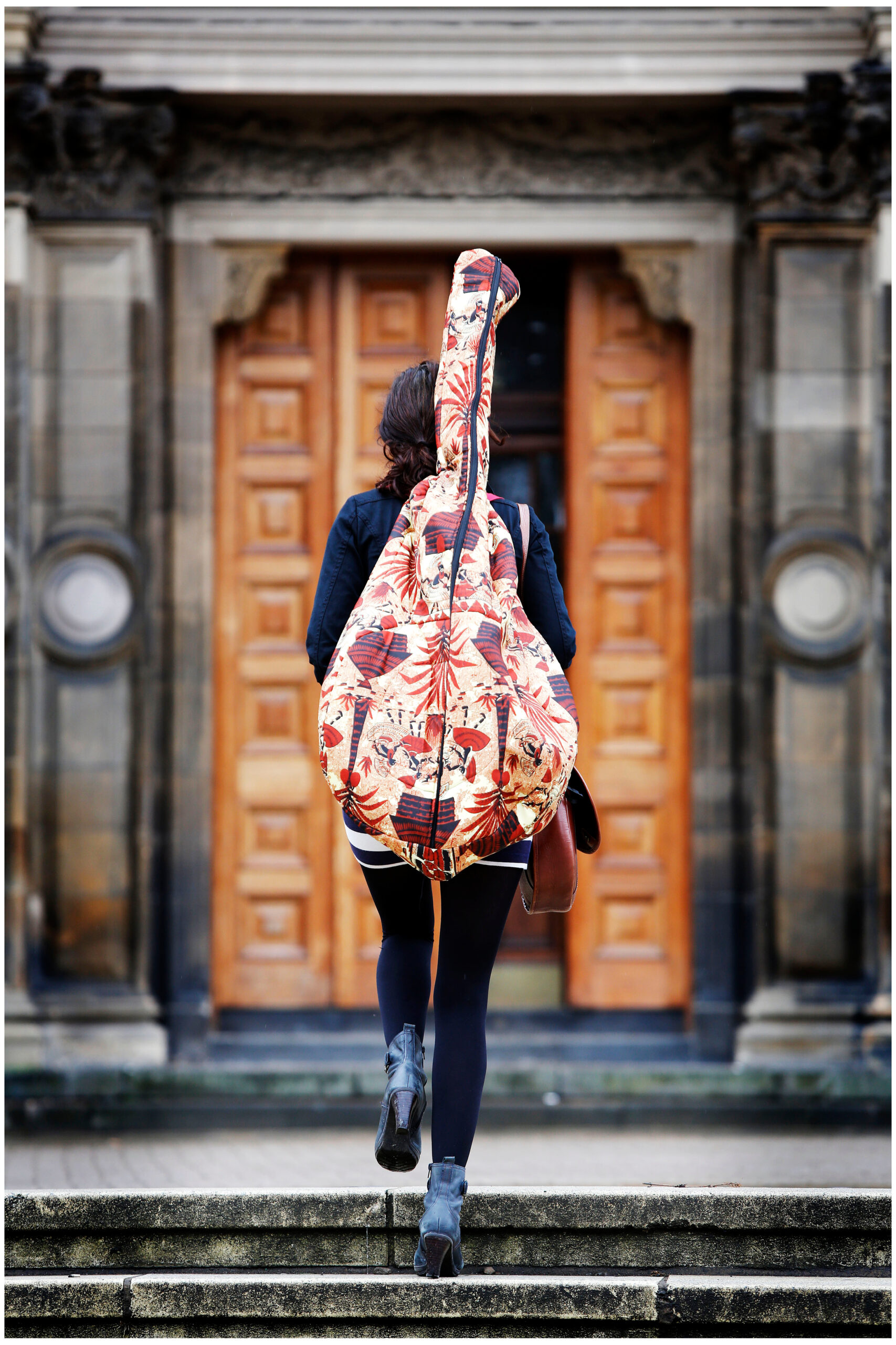 A Music student carries her guitar.