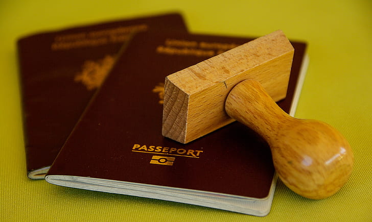 Two passports with wooden stamp on top