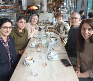 Members of the Caliphal Finances Team and Matthew Gordon and Eugénie Rébillard around a table in a café