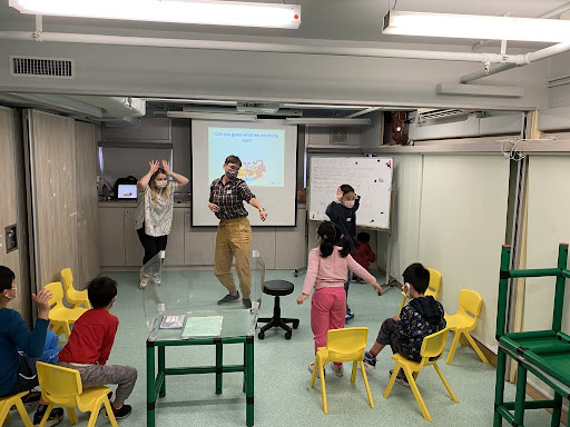 Classroom with young schoolchildren and teacher in lively activity
