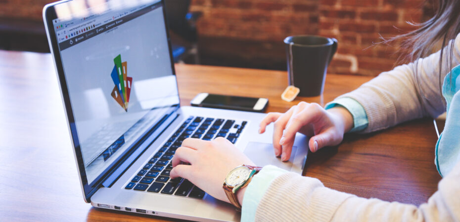 A persons hands a shown typing on a laptop