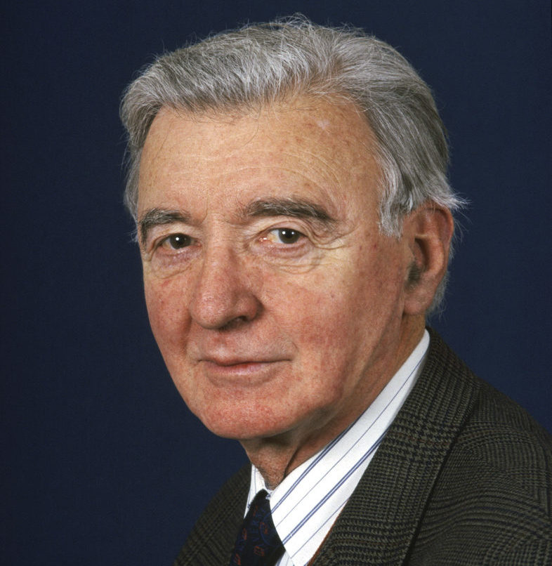 John MacInnes staff portrait from the School of Scottish Studies. John wears a shirt tie and jacket and looks at the camera.