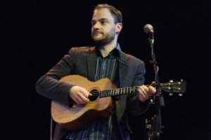 Mike Vass on stage playing tenor guitar