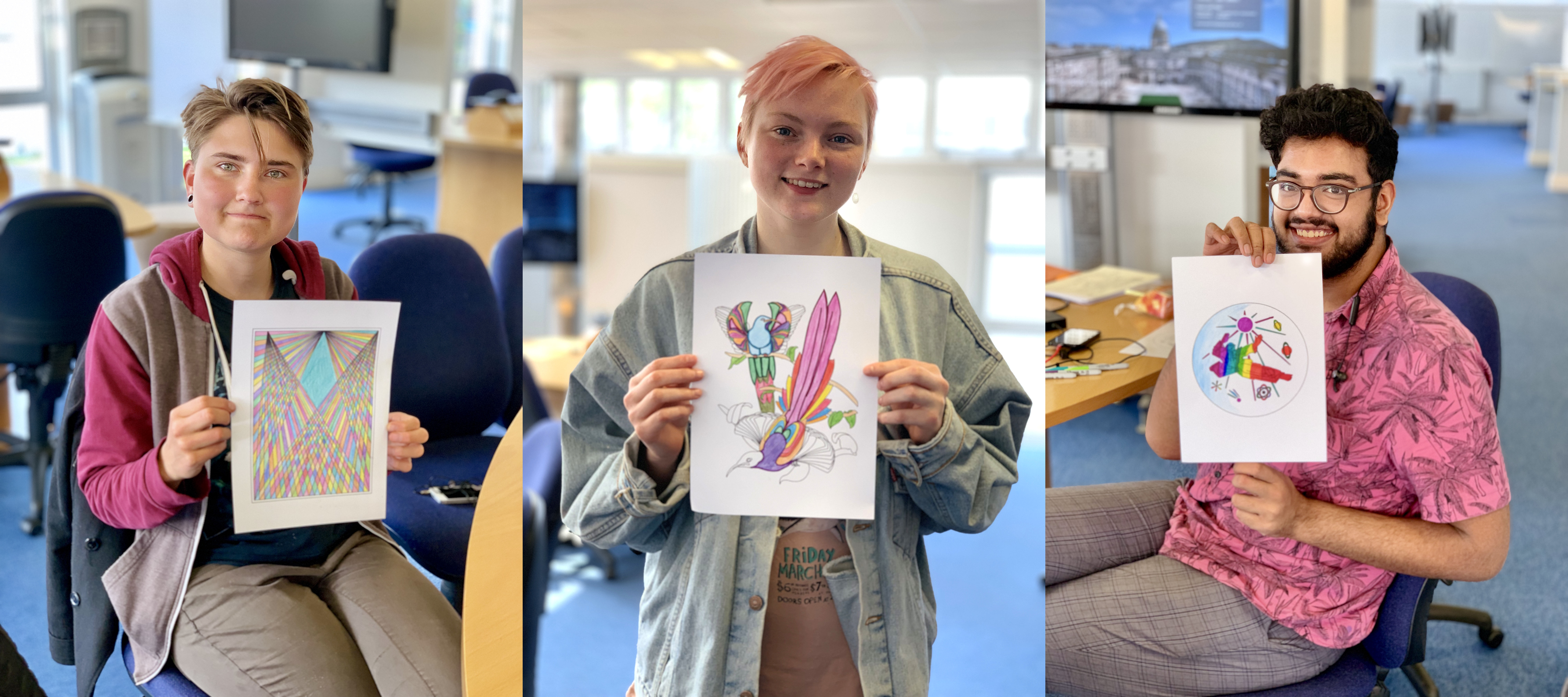 Three students holding up their brightly coloured-in illustrations