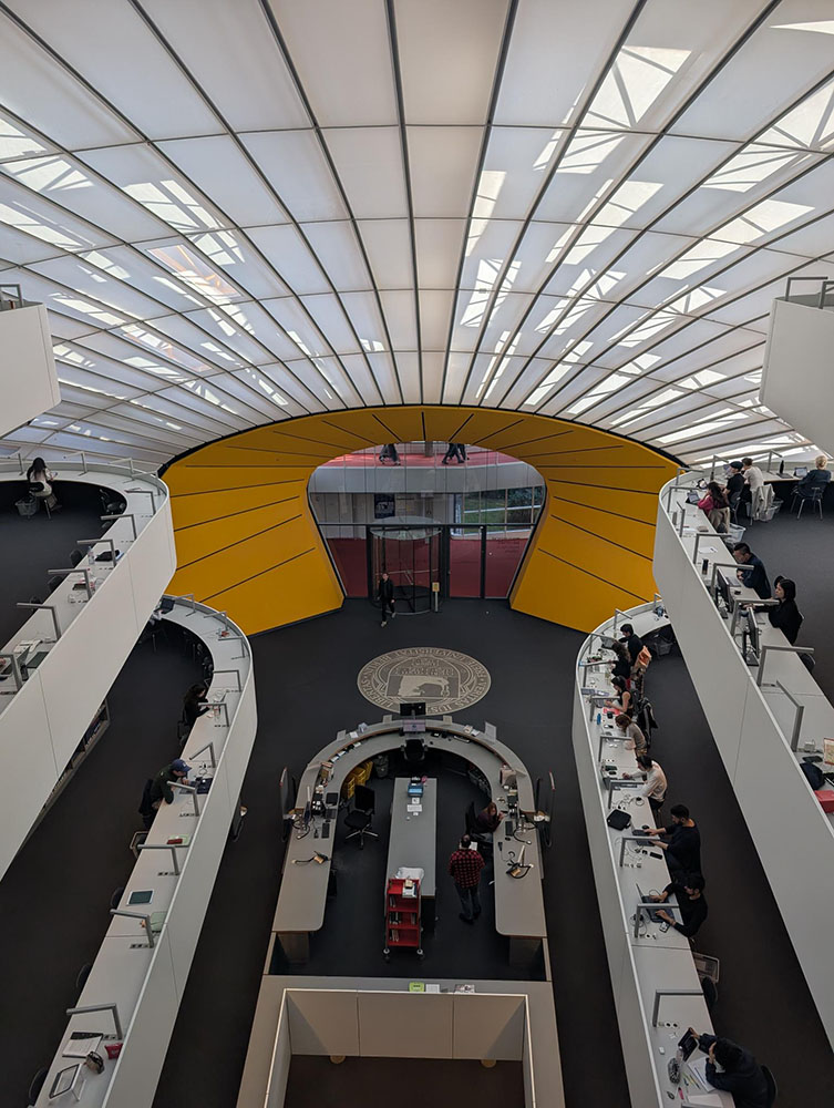 Internal view overlooking the entrance of the Freie Universität Berlin Philological Library, showing students studying at desks
