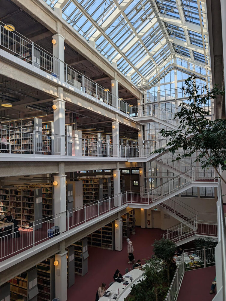 Internal view of the Freie Universität Berlin Campus Library, showing the mezzanine space with rows of bookshelves on each floor 
