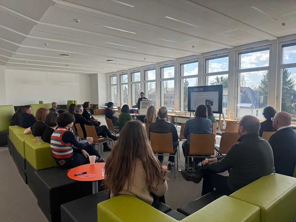 A speaker presenting in front of an audience at the Freie Universität Berlin Central Library