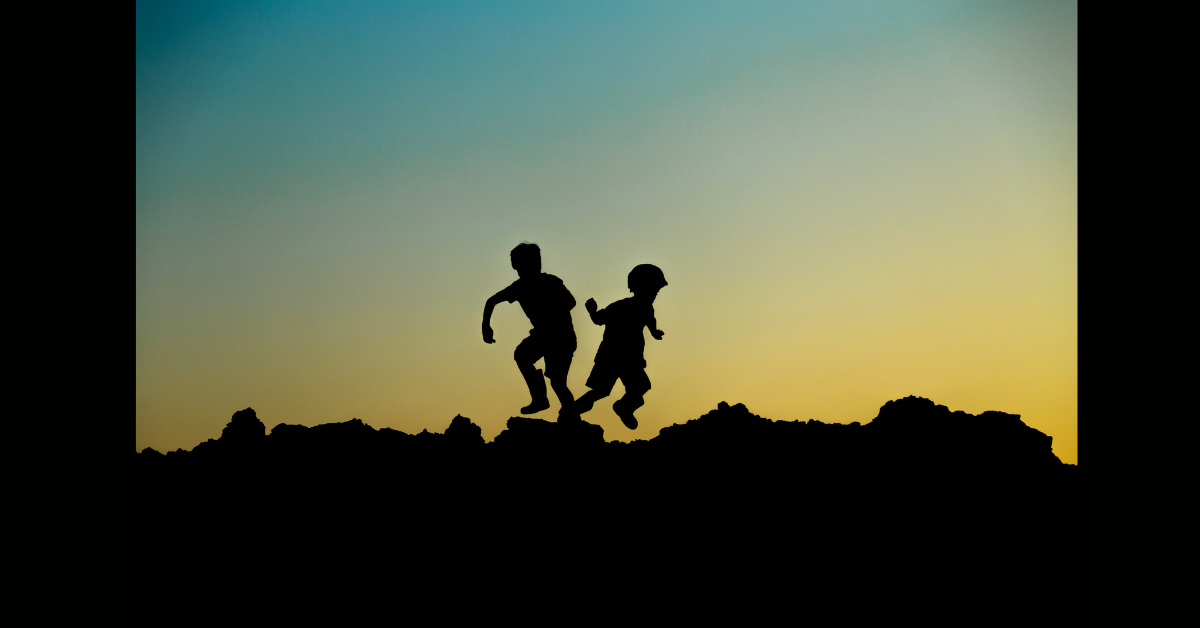 The silhouette of two children