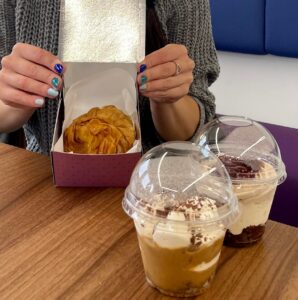 2 plastic pots with mouse in the foreground, and a pastry in a box in the background