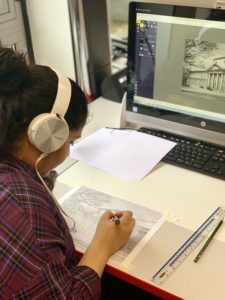 Photograph of workshop participant tracing an image with a pencil.