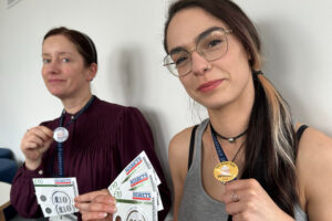 Photo of Delia and Magda showing off their star baker prizes and badges