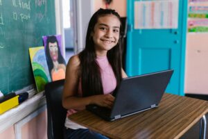 Young girl sitting at a desk with a laptop