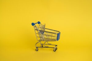 Shopping trolley or cart on yellow background