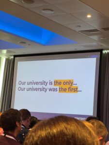 A slide from the conference with text, "Our university is the only... Our university was the first..."