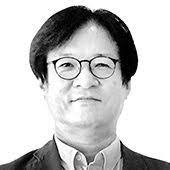 A black and white photograph of Hoon Jaung, who has dark hair and is wearing glasses, a shirt and a jacket.