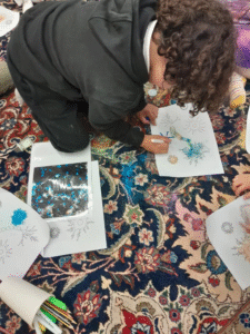 View from above of a boy colouring in on a persian rug