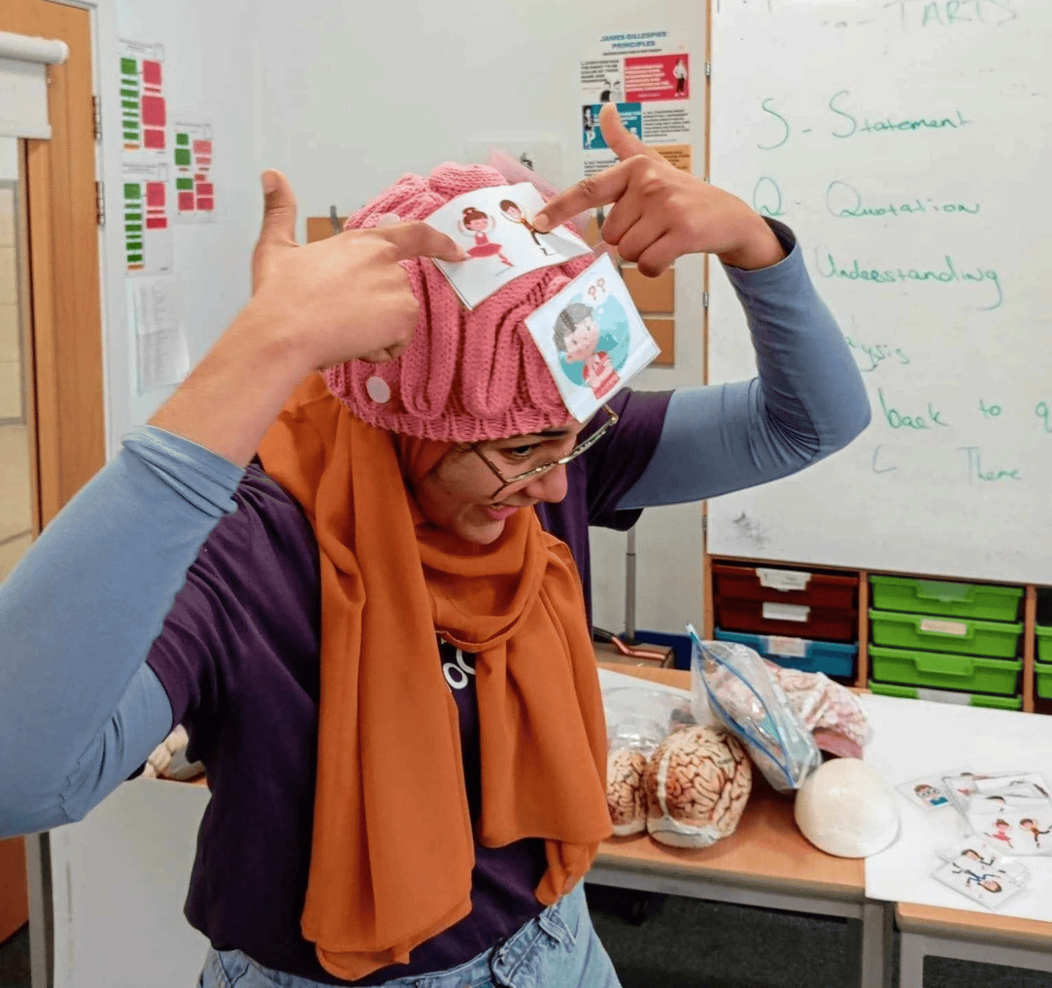demonstrator wearing brain shaped hat with stickers on it