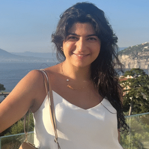 Portrait of Mona in front of a coastal landscape