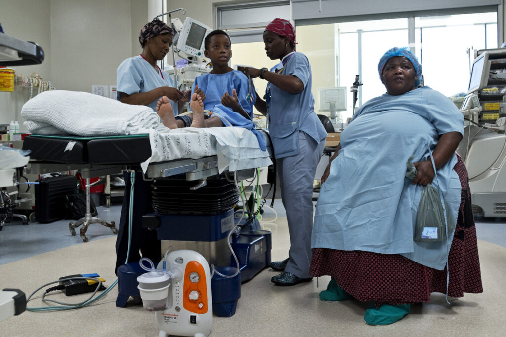 Patient waiting in hospital bed with mother before induction of anaesthesia