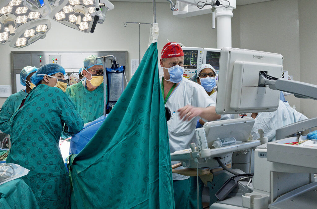 Several surgeons looking at screens in the operating theatre