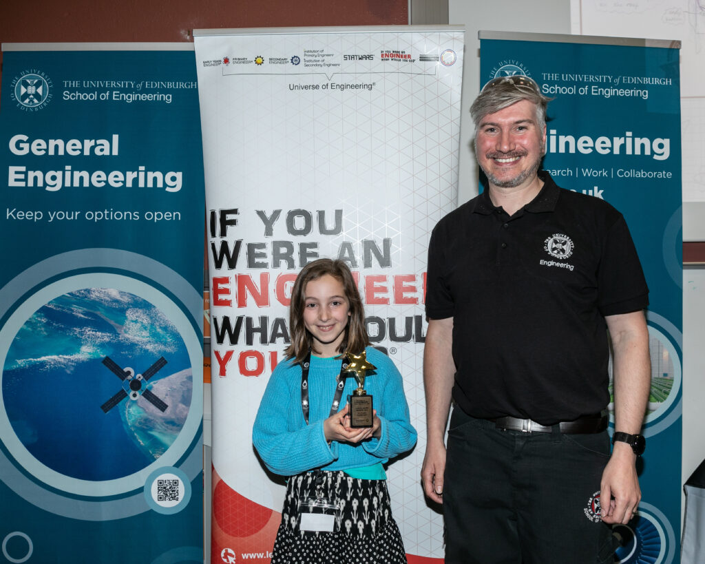 Isla, a primary seven pupil who was presented with the top prize for her design to reduce deforestation by using fallen leaves to manufacture paper, by School technician Iain Gold (right)