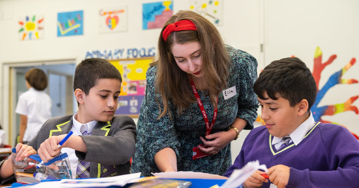 A teacher and two students in a classroom