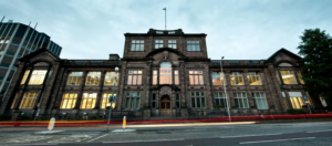 old building at dusk with lights on inside