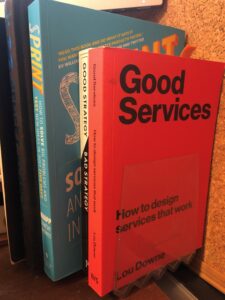 Good Services book in front of a shelf of other design and strategy books