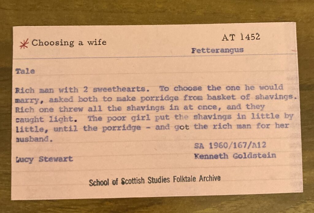 card reads "choosing a wife" Rich man with 2 sweethearts  - to choose one he would marry asked both to make porridge from basket of shavings. Rich one threw all the shavings in at once and they caught light. Poor girl put shavings in little by little and got the rich man for her husband"