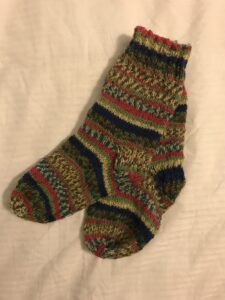 Knitted socks in yellow, brown, red and black stripy pattern