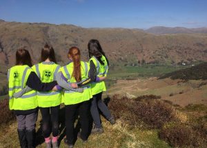 Four girls staring out to the mountains wearing high vis gear