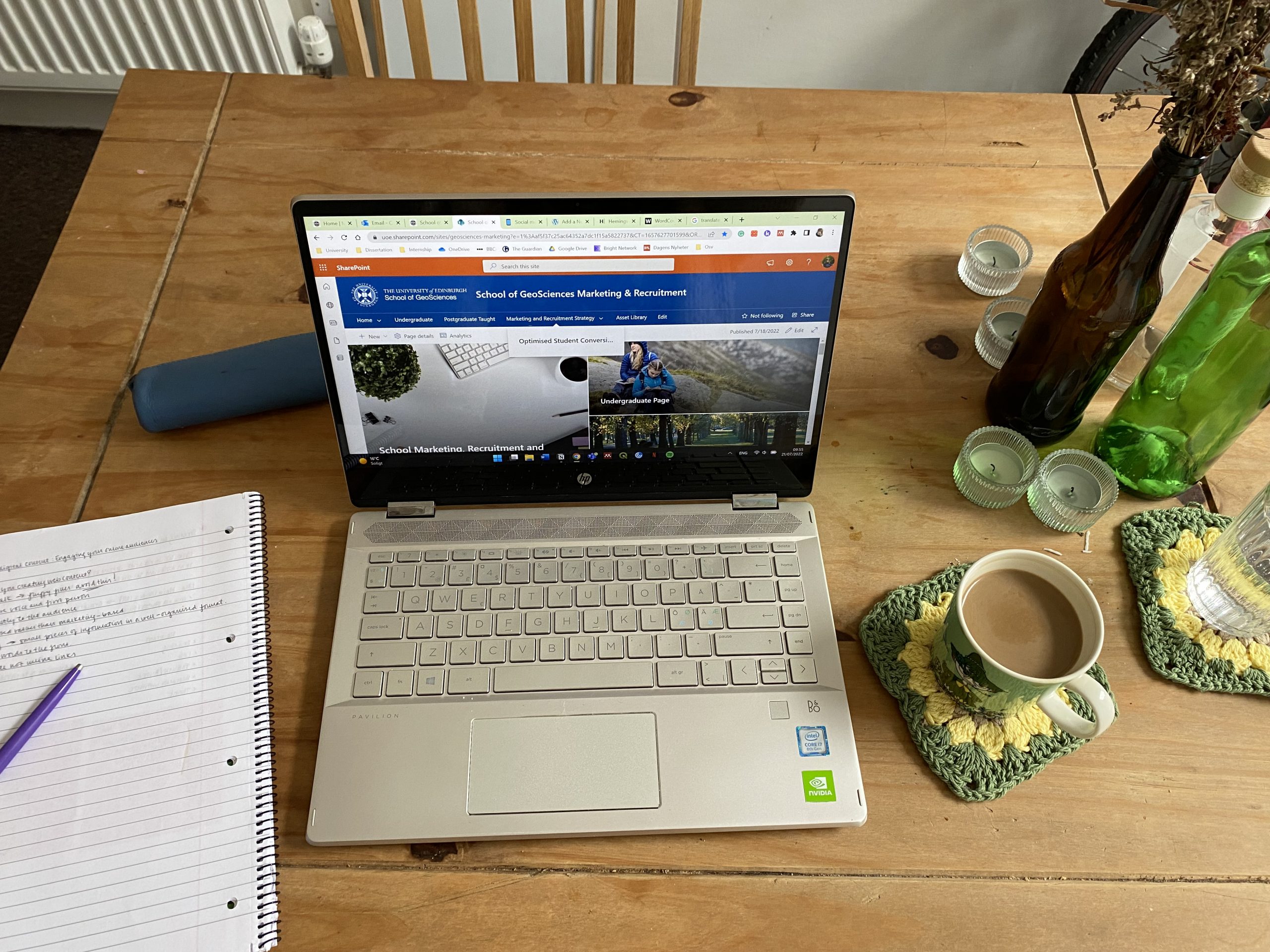 Home office setup: Laptop, notebook, and coffee mug on a wooden table.