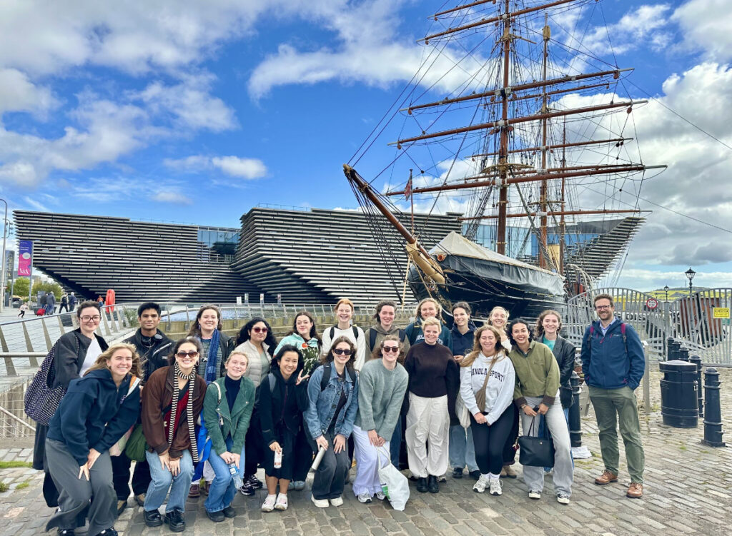 A group of people standing in front of the RMS Discovery ship in Dundee