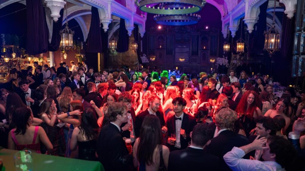 A large crowd of people in formal dress at the Geographical Society Ball.
