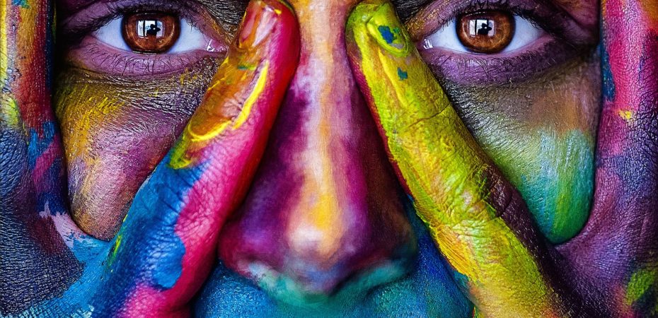 Human female face covered in coloured paints