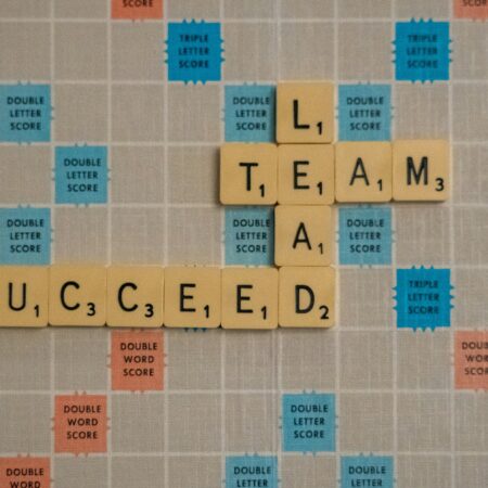 Scrabble board with the words "team", "lead" and "succeed".