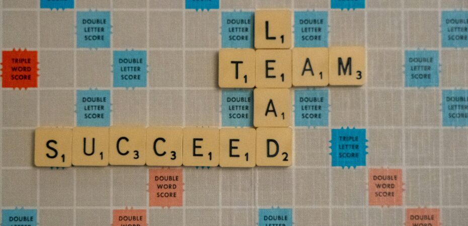 Scrabble board with the words "team", "lead" and "succeed".