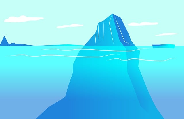 An iceberg or mountain with only it's peak sticking out of the surface of the ocean