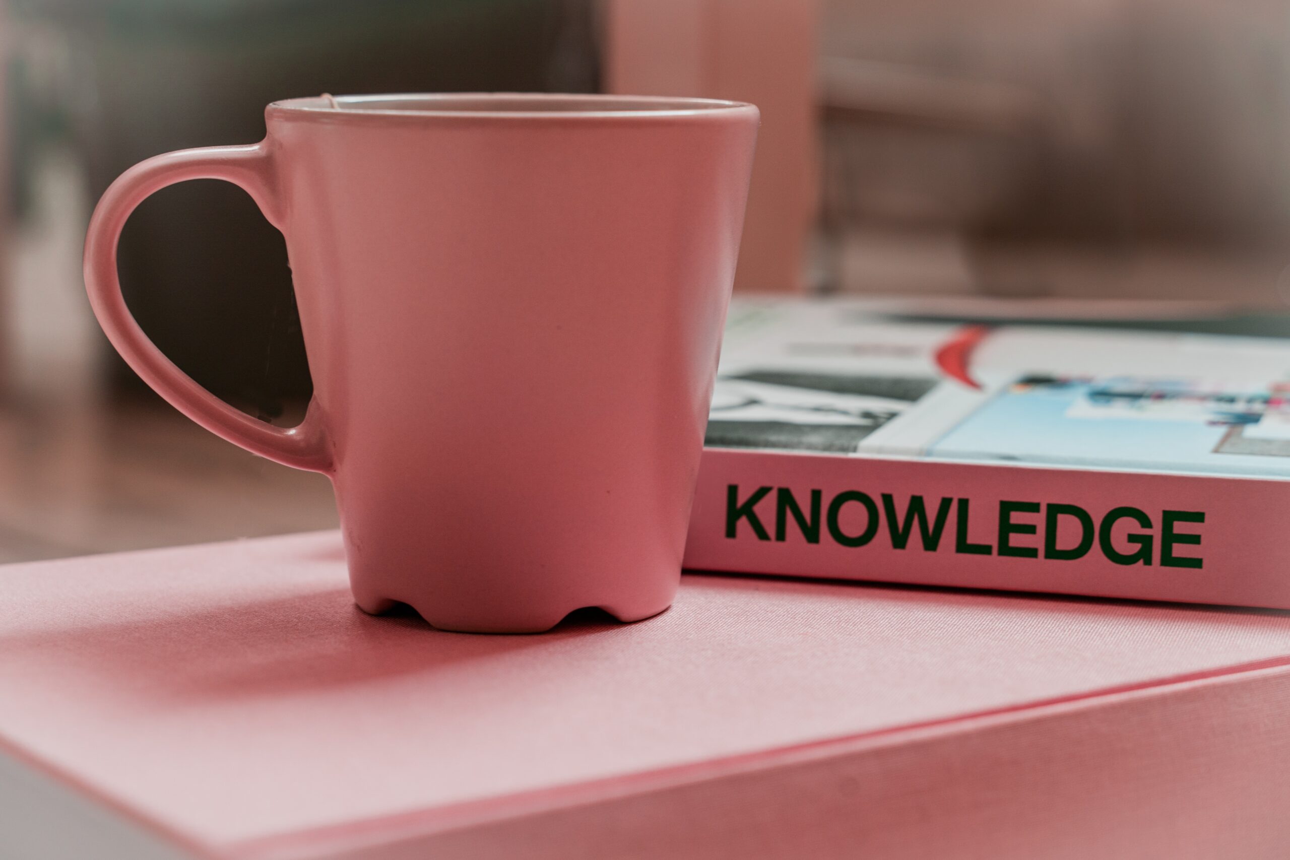 Mug and book with the word knowledge on spine