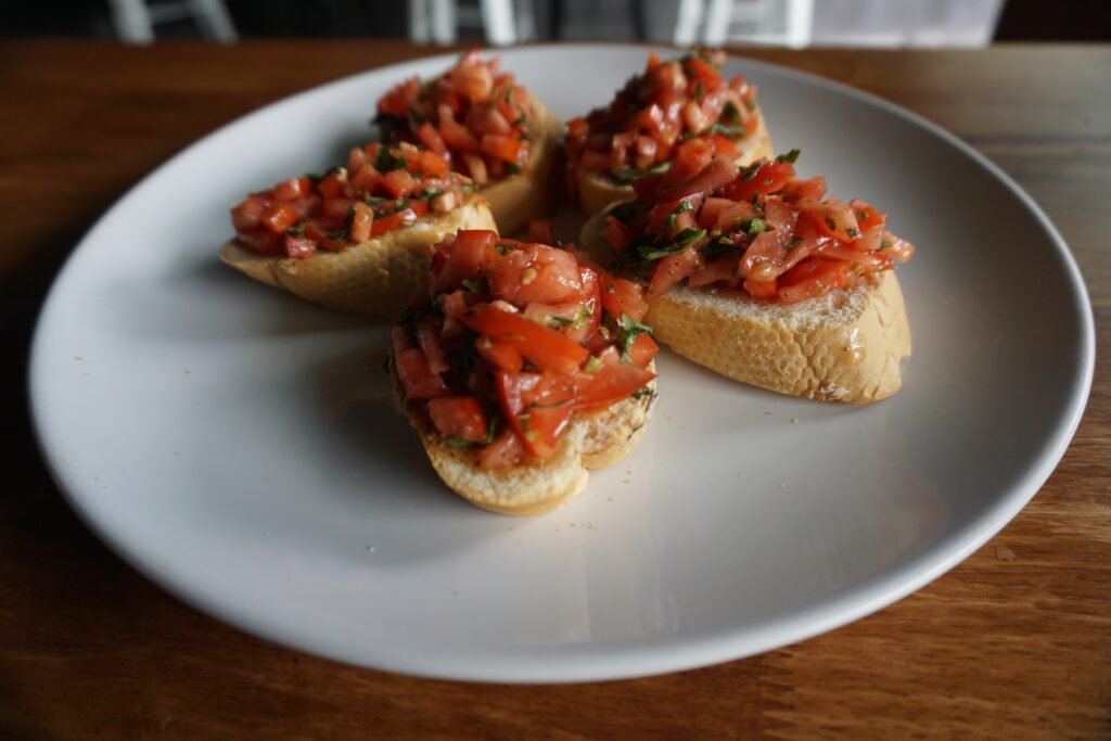 Tomato bruschetta on a white plate.