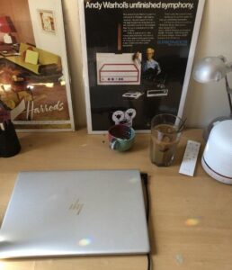 Laptop on desk with coffe and other personal belongings.