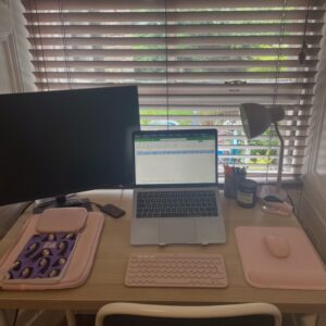 Laptop on desk with extra screen, a keybpard and a mouse ans other personal belongings.