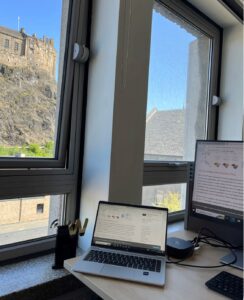 A photo of my desk with laptop and monitor underneath Edinburgh Castle