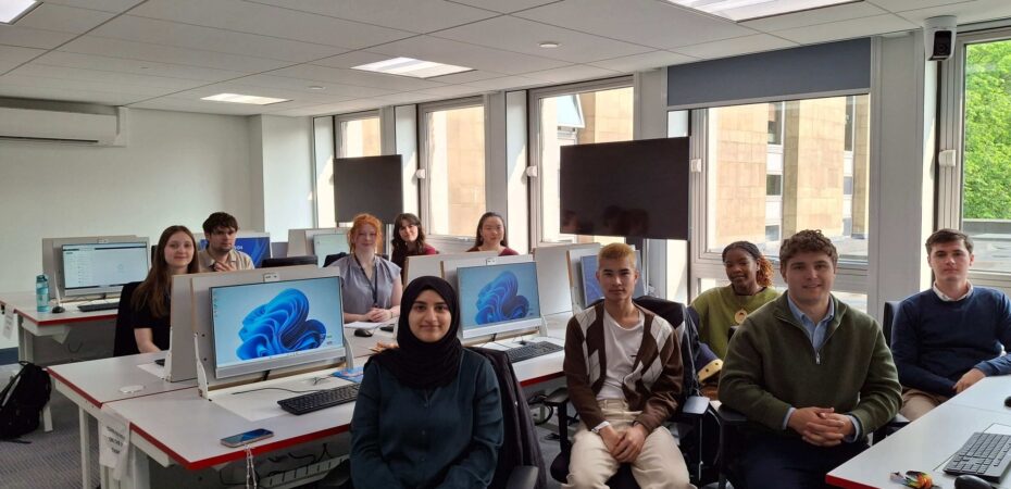 Group of interns sat beside computers in an Argyle House training room.