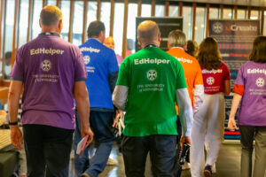 A group of people with their backs to the camera wearing EdHelp shirts.