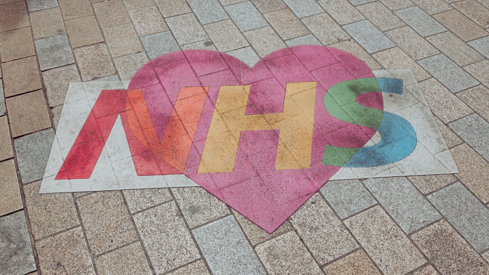 A drawing of a heart on a pavement with the letters NHS across the heart