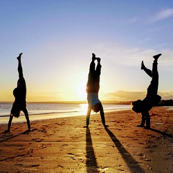 Anisha and friends doing handstands at the beach